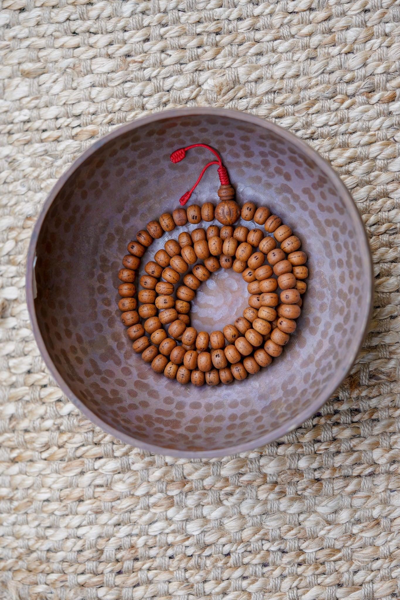 Products 14 mm Bodhi Bead being kept on a copper bowl.