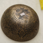 Handmade Tibetan singing bowl with flower, leaf, and vine mandala carvings,  used for meditation and sound healing.