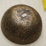 Handmade Tibetan singing bowl with flower, leaf, and vine mandala carvings,  used for meditation and sound healing.