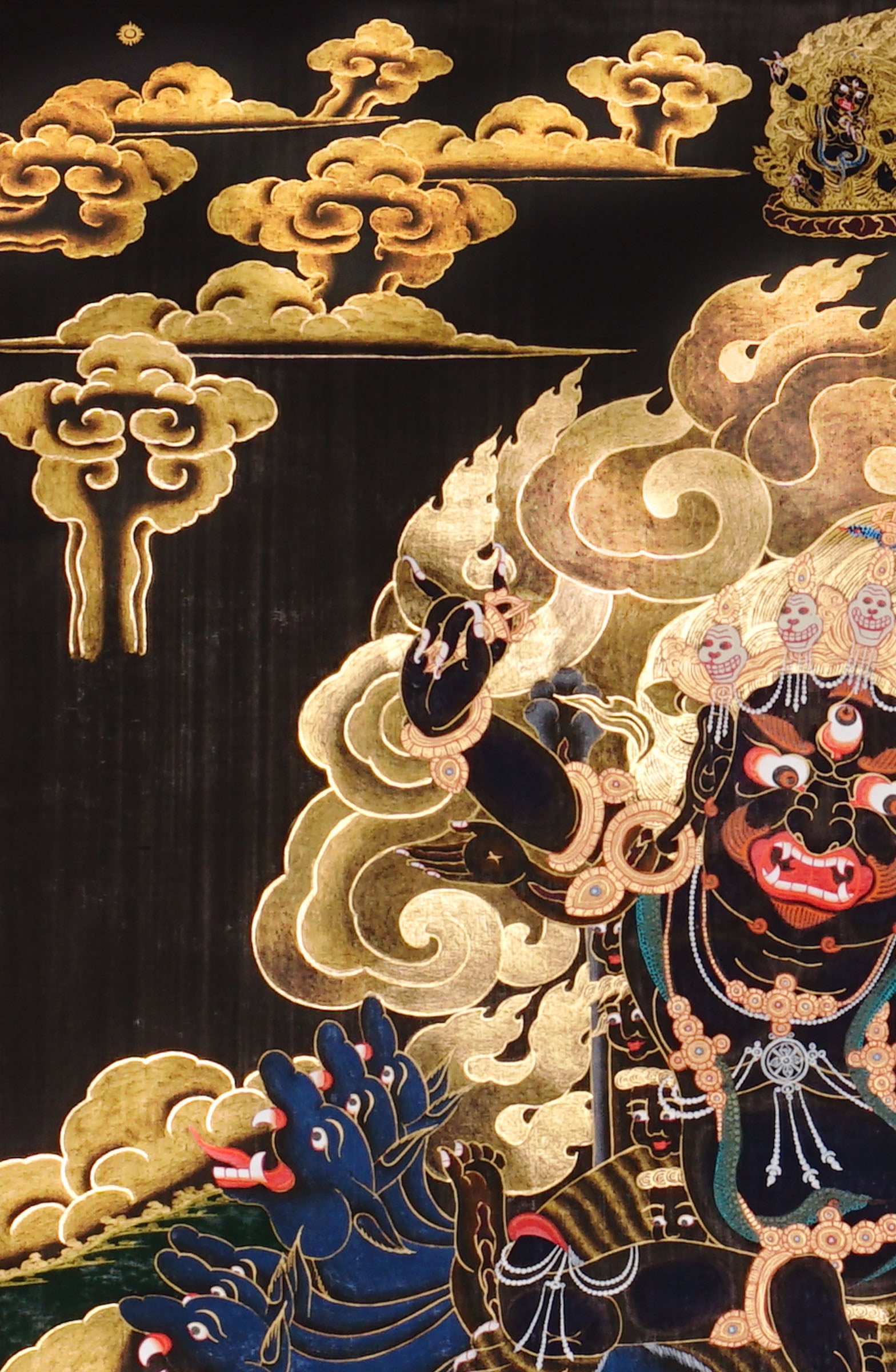 Vajra Guru Thangka Painting showing a wrathful Tibetan Buddhist protector deity riding a fierce blue mount, surrounded by flame aura, golden clouds, skull crown, sacred ornaments, lotus base and offering details.