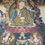 Guru Rinpoche Thangka Painting  seated on a lotus throne with vajra, skull cup, khatvanga staff, radiant halo, two supporting female figures, offering bowl, dragons, clouds and Himalayan landscape details.
