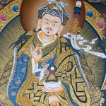 Guru Rinpoche Thangka Painting  seated on a lotus throne with vajra, skull cup, khatvanga staff, radiant halo, two supporting female figures, offering bowl, dragons, clouds and Himalayan landscape details.