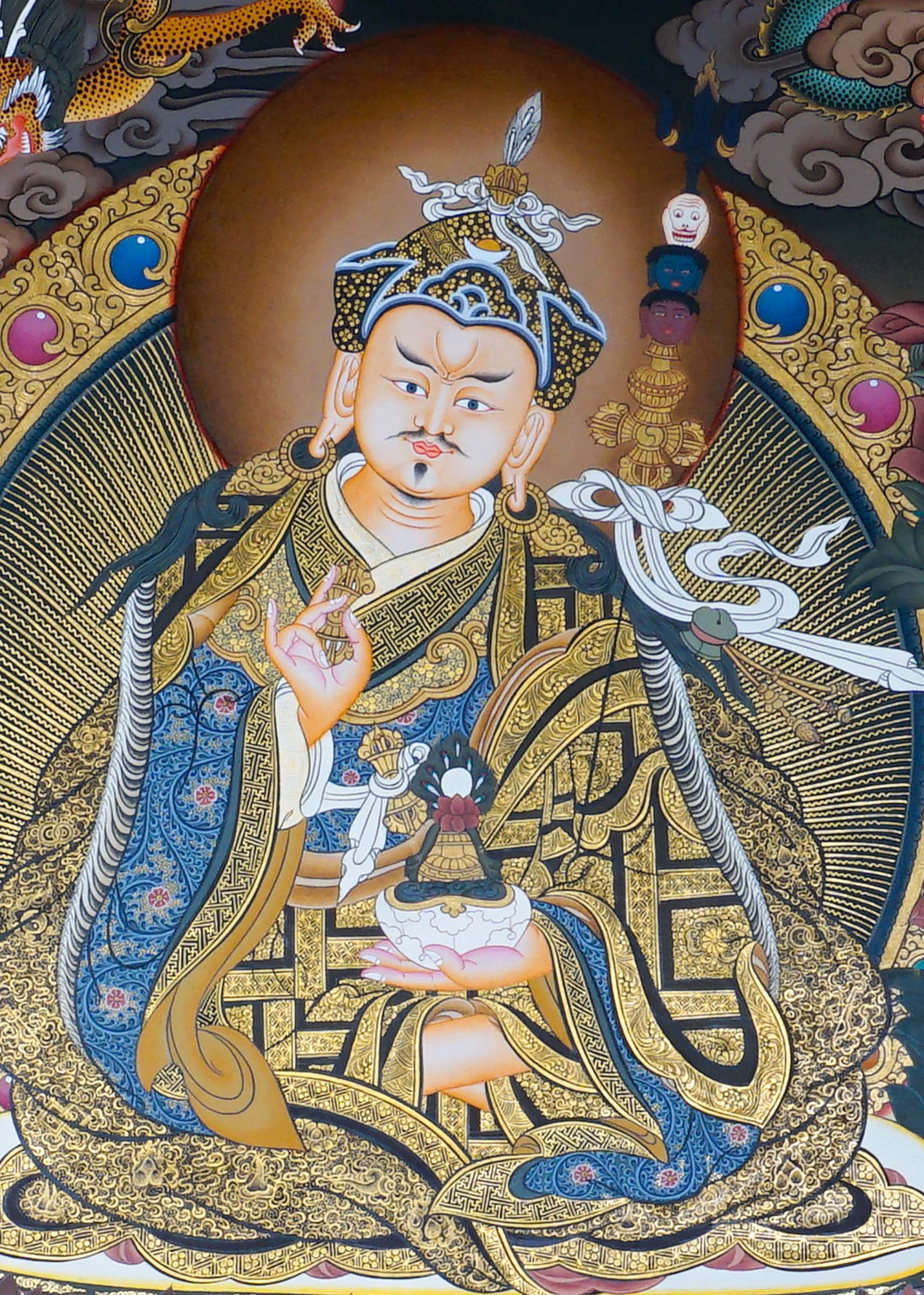 Guru Rinpoche Thangka Painting  seated on a lotus throne with vajra, skull cup, khatvanga staff, radiant halo, two supporting female figures, offering bowl, dragons, clouds and Himalayan landscape details.