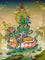 Green Tara thangka painting Tibetan goddess seated on lotus holding blue lotus in detailed Himalayan landscape