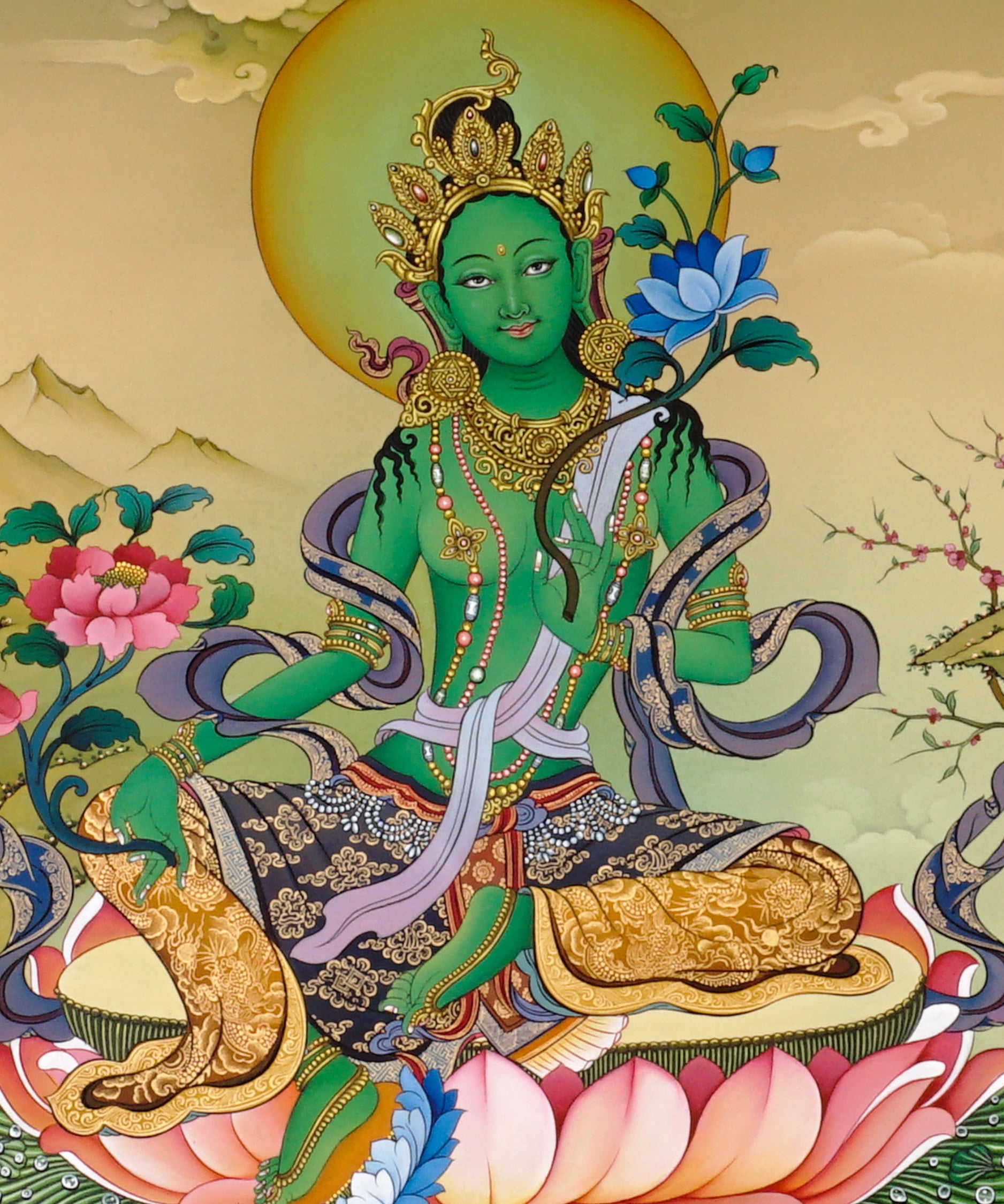 Green Tara thangka painting Tibetan goddess seated on lotus holding blue lotus in detailed Himalayan landscape