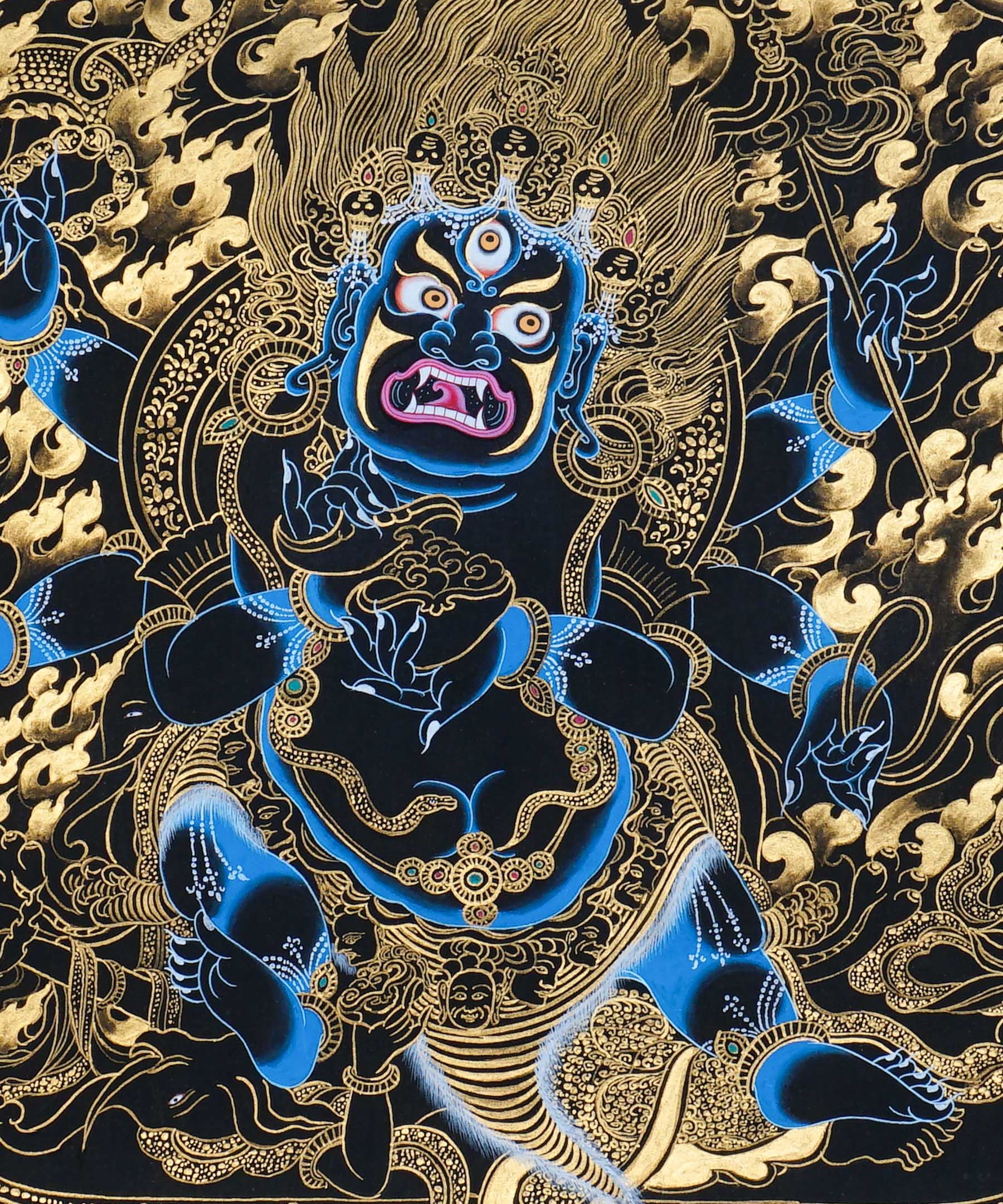 Mahakala thangka painting showing a wrathful blue Mahakala deity with multiple arms, flaming aura, gold clouds, dragon motif, and black background in traditional Tibetan Buddhist style.