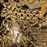 black and gold Zambhala thangka painting showing Tibetan wealth deity with mongoose and intricate gold detailing