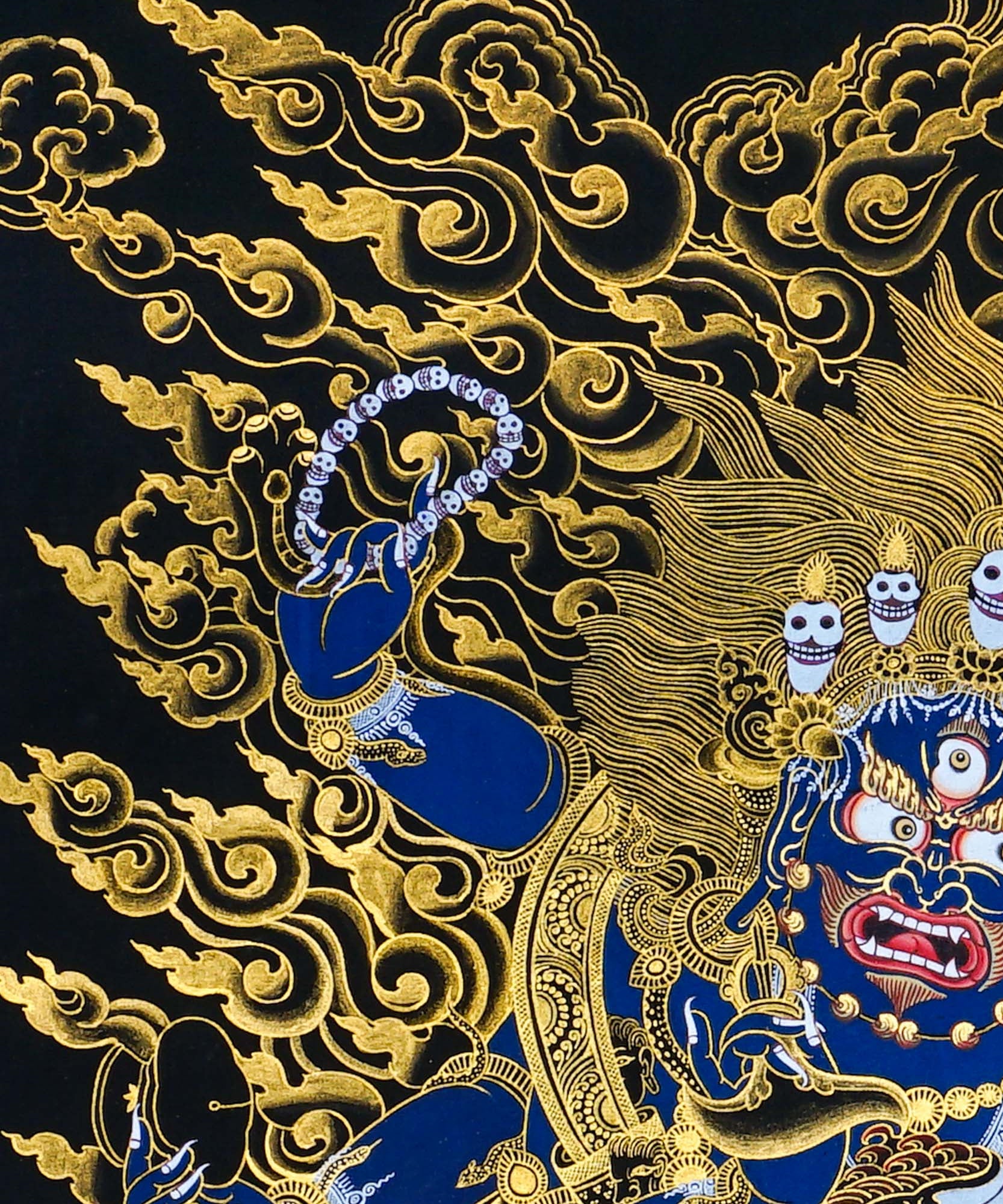Close-up detail of Six Hand Mahakala Thangka Painting, six-armed wrathful protector in black, gold and blue with flame motifs and lotus base