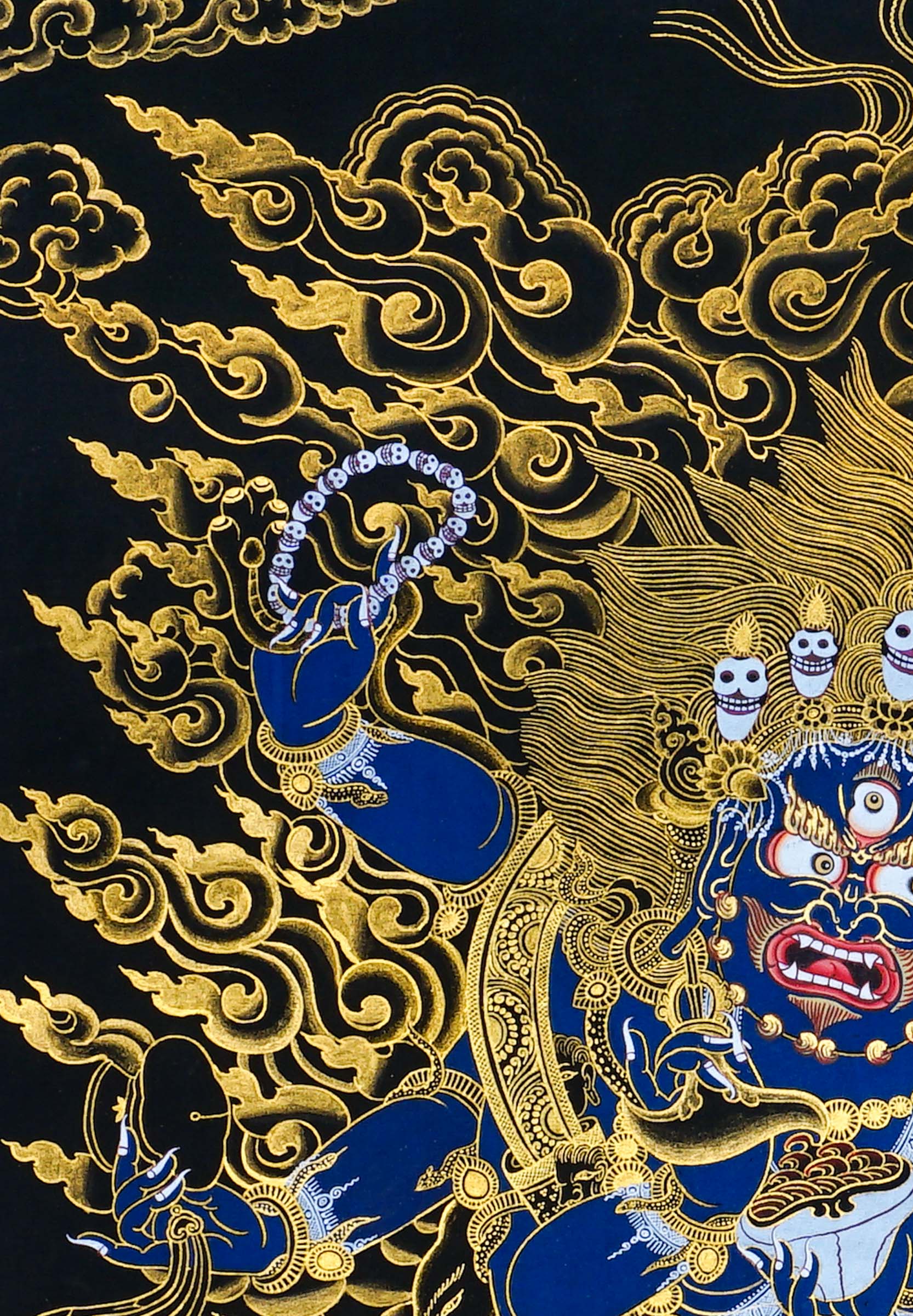 Close-up detail of Six Hand Mahakala Thangka Painting, six-armed wrathful protector in black, gold and blue with flame motifs and lotus base