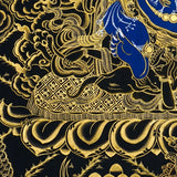 Close-up detail of Six Hand Mahakala Thangka Painting, six-armed wrathful protector in black, gold and blue with flame motifs and lotus base