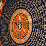Tibetan mantra mandala artwork with sacred script and decorative floral borders
