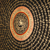 Tibetan mantra mandala artwork with gold script on black background