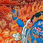 Vajrapani thangka painting showing a blue wrathful Tibetan Buddhist protector deity holding a raised vajra, surrounded by flames and seated on a lotus throne against a vivid orange-red background.