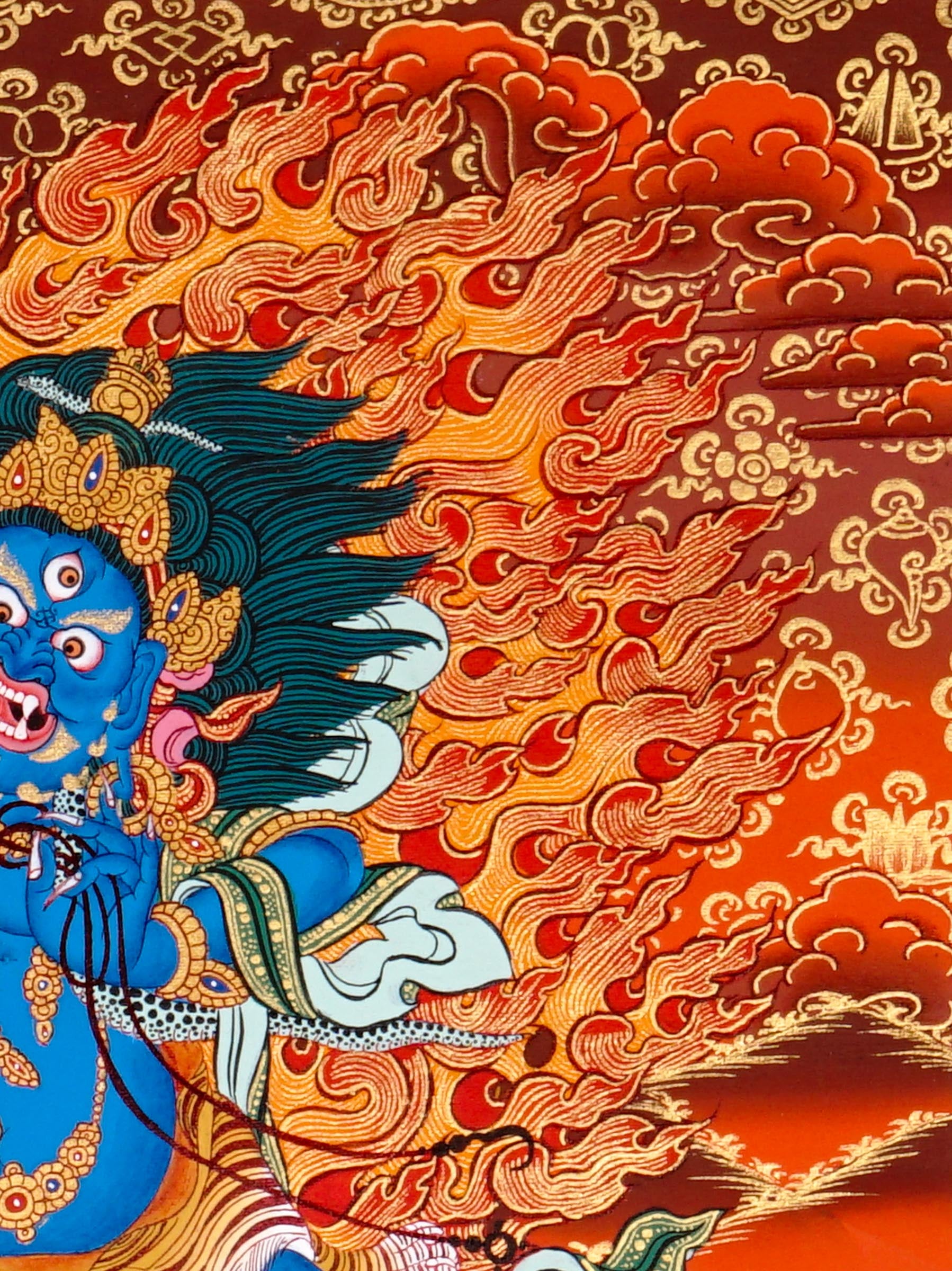 Vajrapani thangka painting showing a blue wrathful Tibetan Buddhist protector deity holding a raised vajra, surrounded by flames and seated on a lotus throne against a vivid orange-red background.