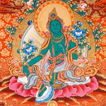 Green Tara Thangka Painting showing the Tibetan Buddhist goddess seated on a pink lotus throne with one leg extended, holding a lotus flower, surrounded by a radiant halo, sacred ornaments and red-gold background.