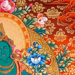 Green Tara Thangka Painting showing the Tibetan Buddhist goddess seated on a pink lotus throne with one leg extended, holding a lotus flower, surrounded by a radiant halo, sacred ornaments and red-gold background.
