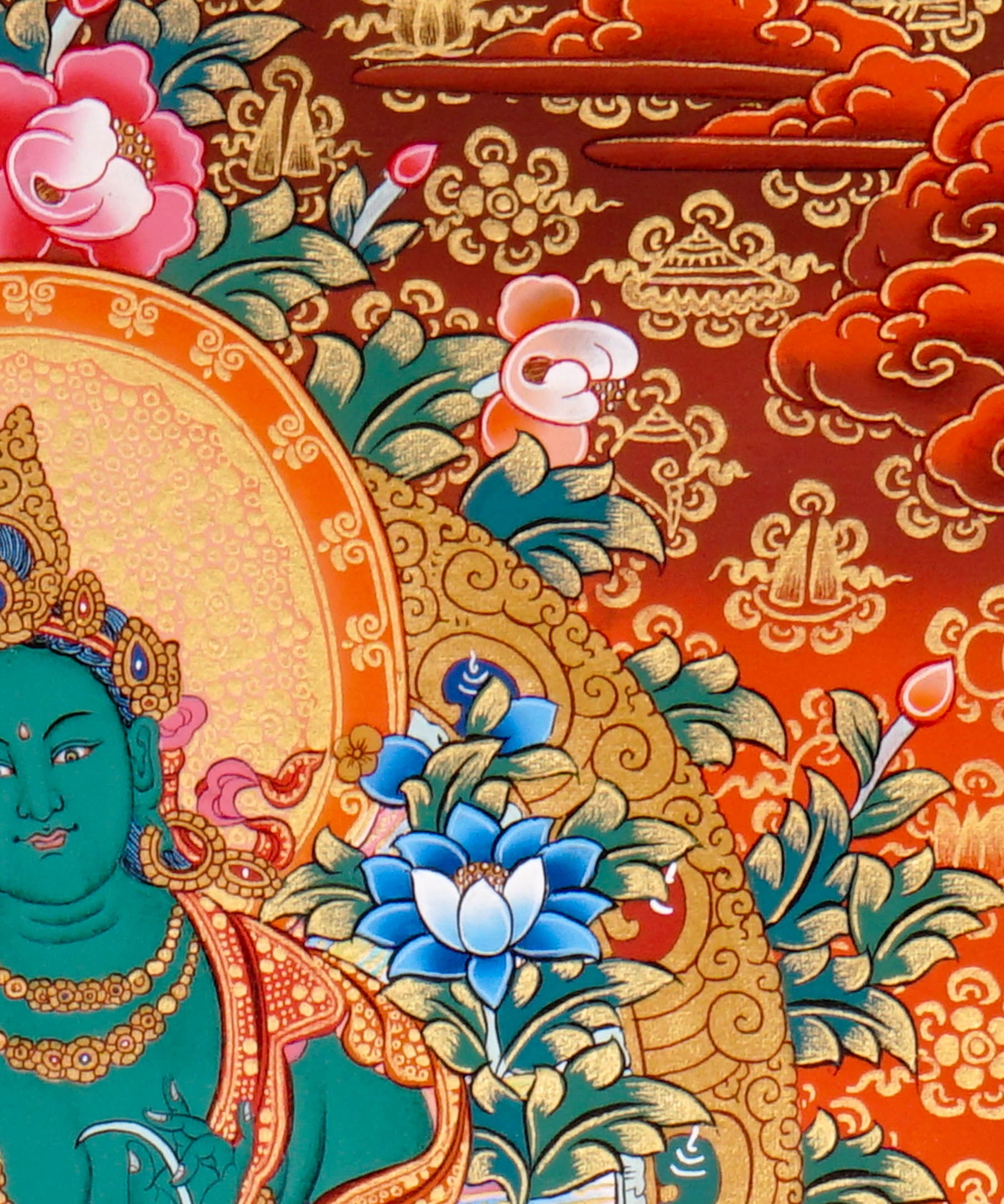 Green Tara Thangka Painting showing the Tibetan Buddhist goddess seated on a pink lotus throne with one leg extended, holding a lotus flower, surrounded by a radiant halo, sacred ornaments and red-gold background.