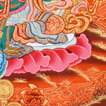 Green Tara Thangka Painting showing the Tibetan Buddhist goddess seated on a pink lotus throne with one leg extended, holding a lotus flower, surrounded by a radiant halo, sacred ornaments and red-gold background.