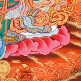 Green Tara Thangka Painting showing the Tibetan Buddhist goddess seated on a pink lotus throne with one leg extended, holding a lotus flower, surrounded by a radiant halo, sacred ornaments and red-gold background.