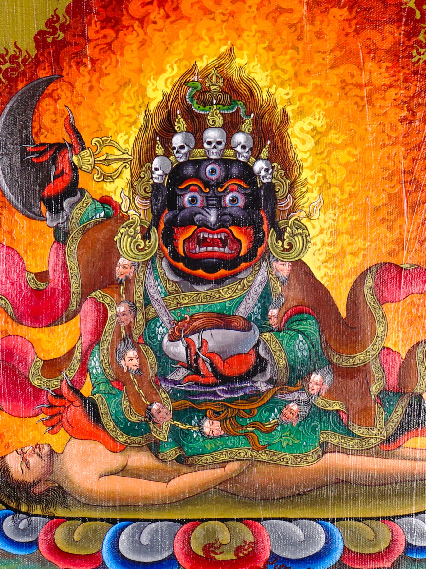 Mahakala Oil Painting showing a wrathful Tibetan Buddhist Dharma protector with black face, skull crown, curved knife, skull cup, flame aura, lotus base, offering symbols and golden textured background.