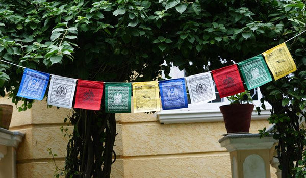 5 Buddhist deities praying flag being hanged