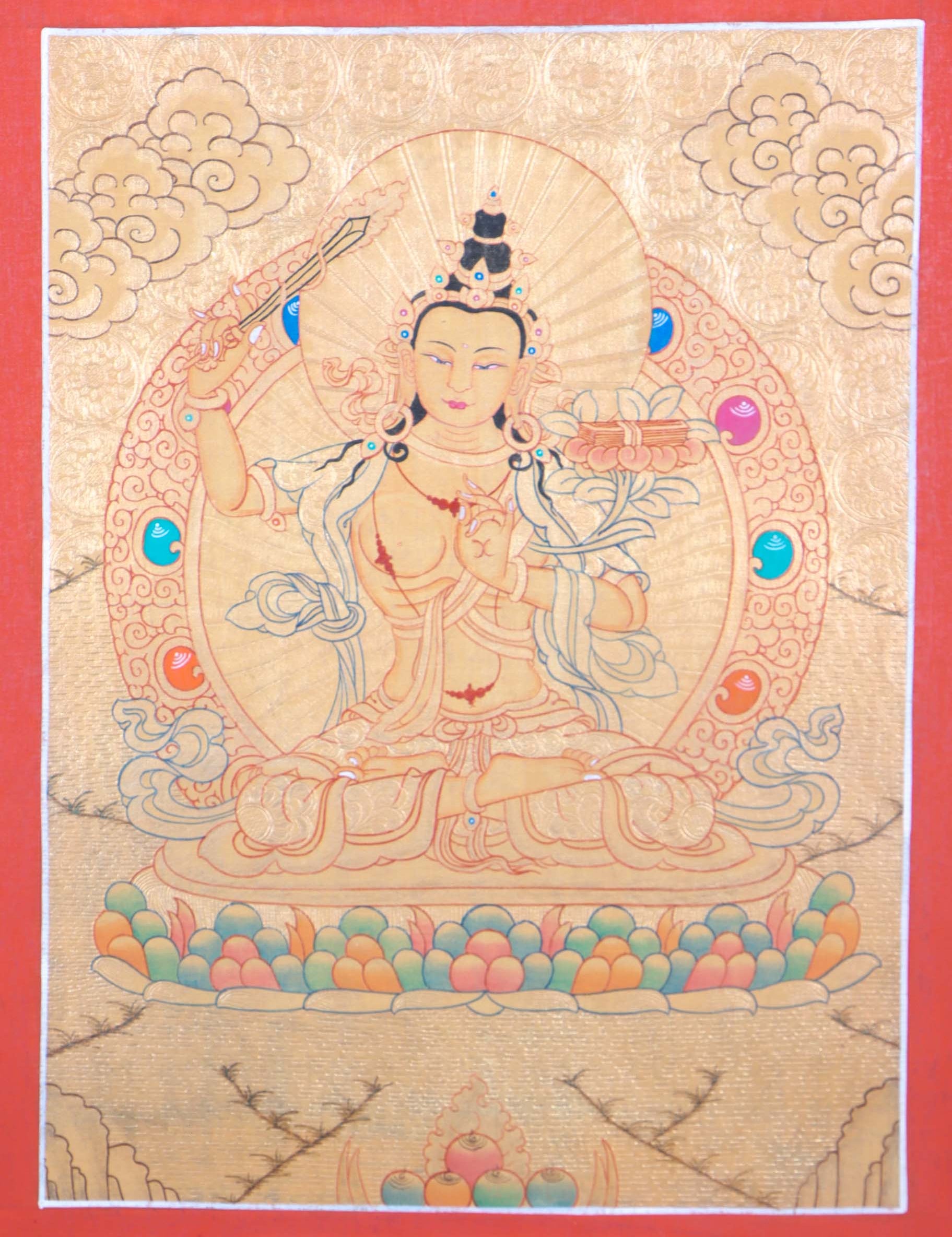 Buddhist Thangka are used as support for one's meditation practice. Manjushri is the Bodhisattva of transcendent wisdom. With the double-edged sword on his right hand he cuts through the illusion and with his left hand holds a lotus with book of Prajna Paramita.