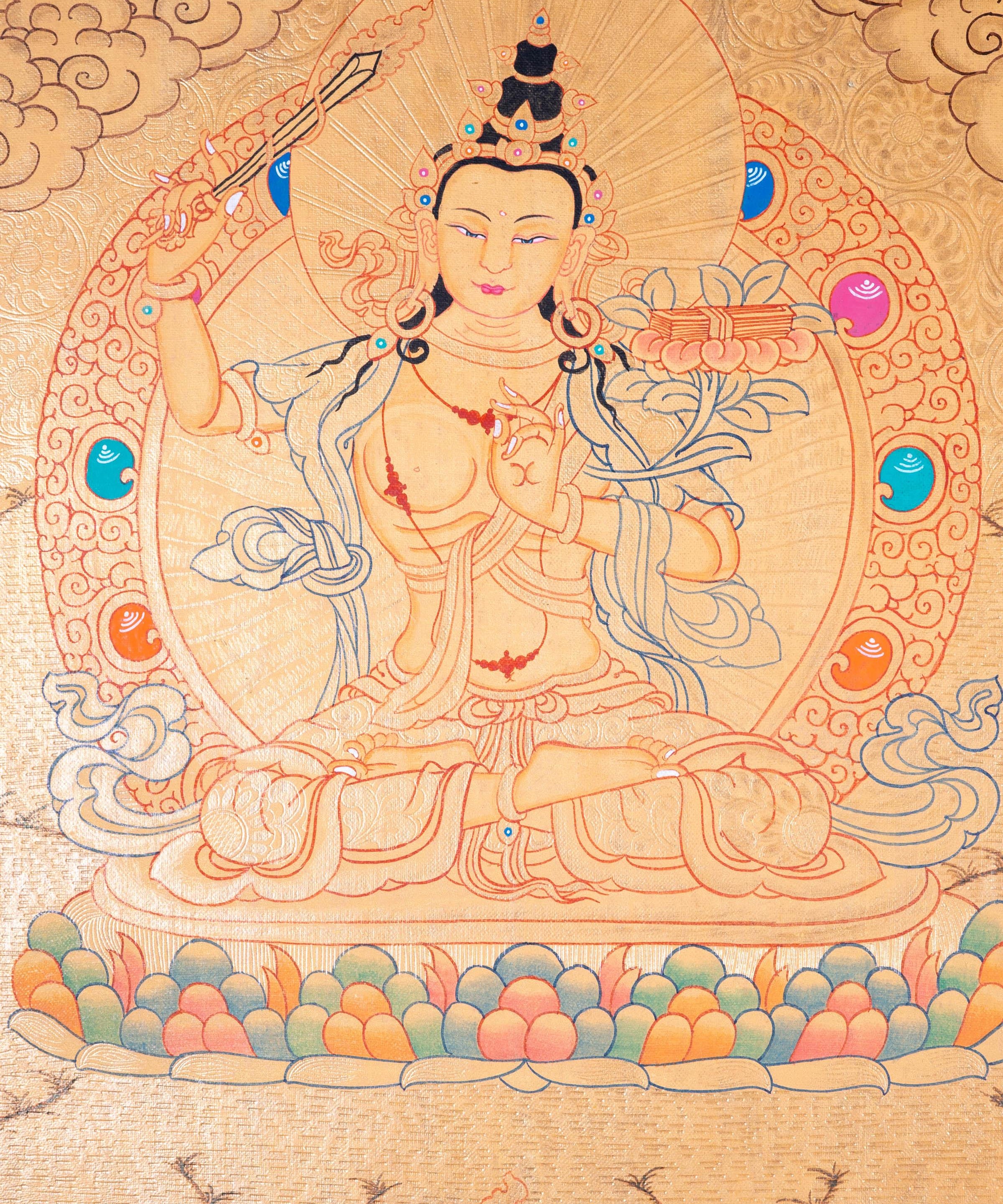 Buddhist Thangka are used as support for one's meditation practice. Manjushri is the Bodhisattva of transcendent wisdom. With the double-edged sword on his right hand he cuts through the illusion and with his left hand holds a lotus with book of Prajna Paramita.