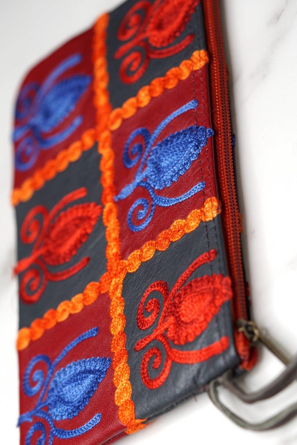 Vibrant colorful purse with kashmiri hand embroidery, has a secure zip top closure, ethically made in Nepal.