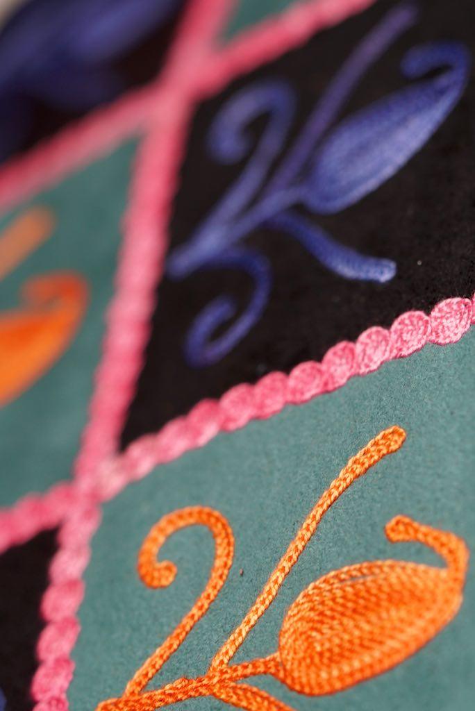 Unique style purse with cashmere handwork embroidery that comes with a wristlet and a secure zip top closure.