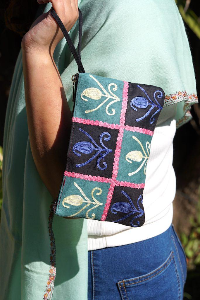 Unique style purse with cashmere handwork embroidery that comes with a wristlet and a secure zip top closure.