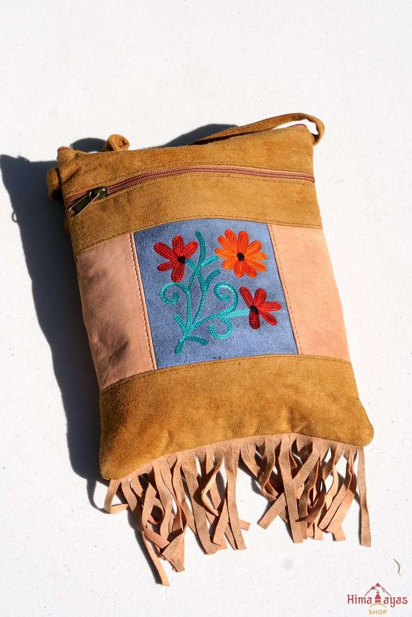 A small sling style, cross body bag with tassel/fringe at the bottom giving it a bohemian chic look.