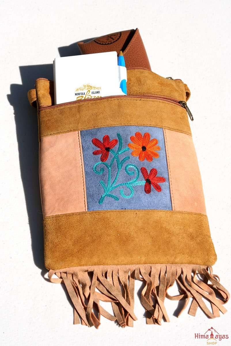 A small sling style, cross body bag with tassel/fringe at the bottom giving it a bohemian chic look.