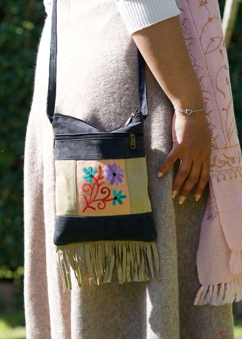 A small sling style, cross body bag with tassel/fringe at the bottom giving it a bohemian chic look.