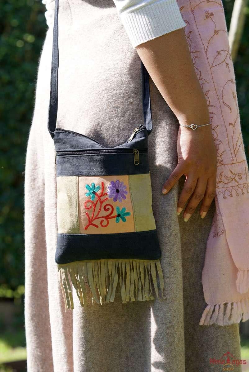 A small sling style, cross body bag with tassel/fringe at the bottom giving it a bohemian chic look.