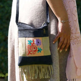 A small sling style, cross body bag with tassel/fringe at the bottom giving it a bohemian chic look.