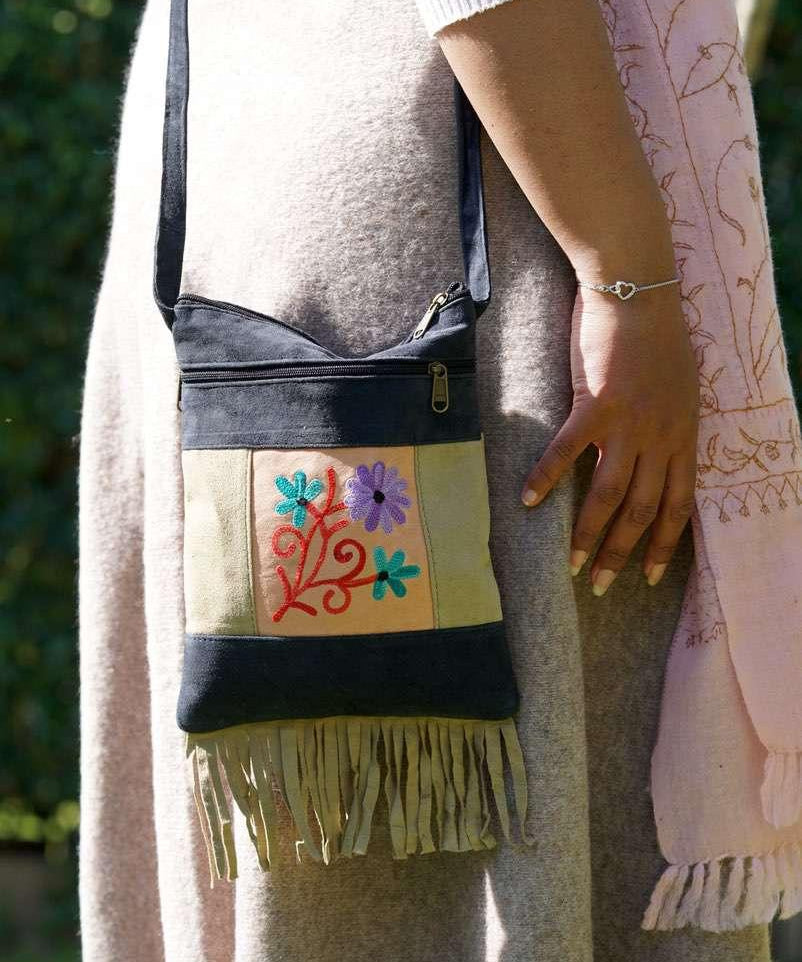 A small sling style, cross body bag with tassel/fringe at the bottom giving it a bohemian chic look.
