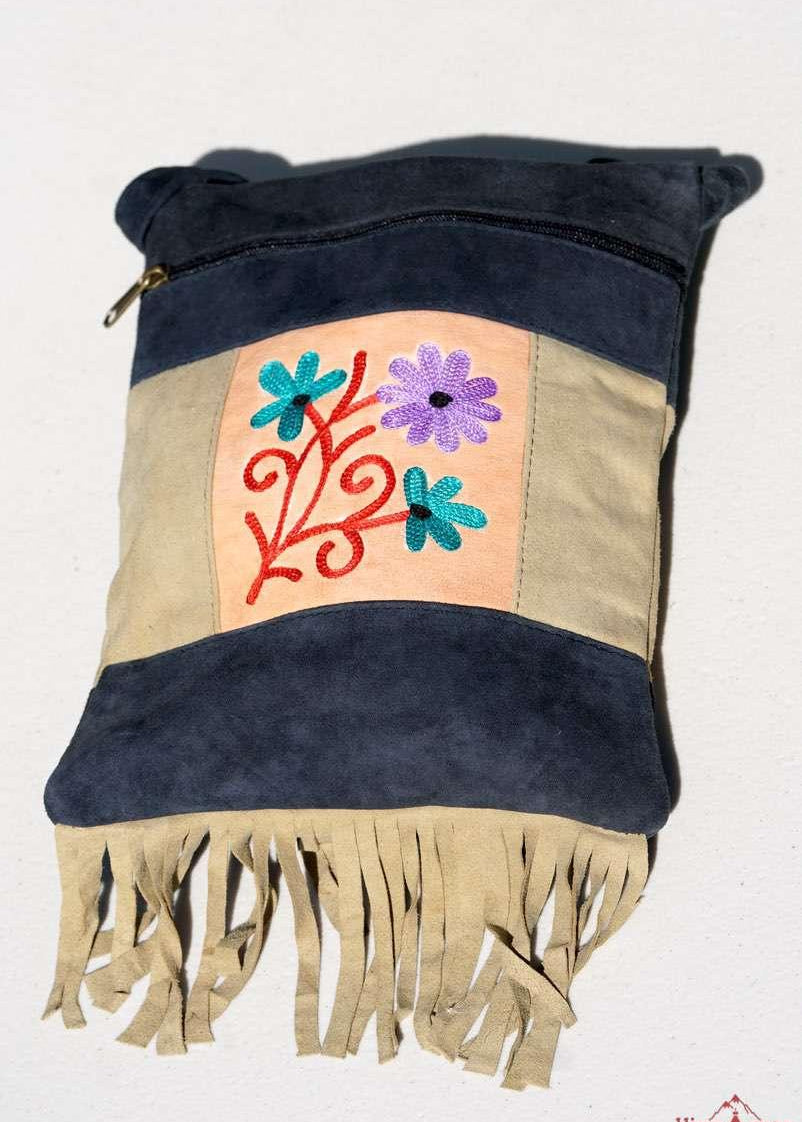 A small sling style, cross body bag with tassel/fringe at the bottom giving it a bohemian chic look.