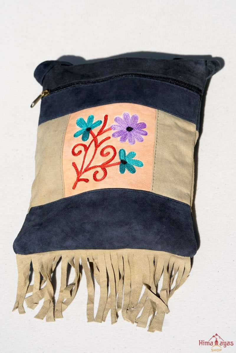 A small sling style, cross body bag with tassel/fringe at the bottom giving it a bohemian chic look.