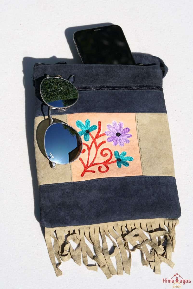 A small sling style, cross body bag with tassel/fringe at the bottom giving it a bohemian chic look.