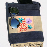 A small sling style, cross body bag with tassel/fringe at the bottom giving it a bohemian chic look.