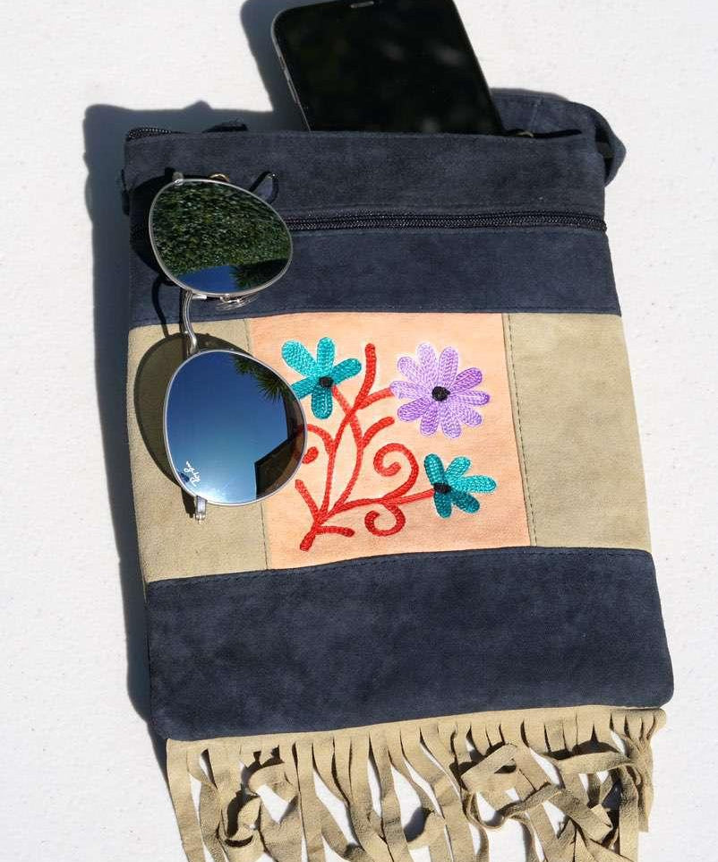A small sling style, cross body bag with tassel/fringe at the bottom giving it a bohemian chic look.
