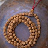 Rudraksha Bead Mala on top of a bowl 